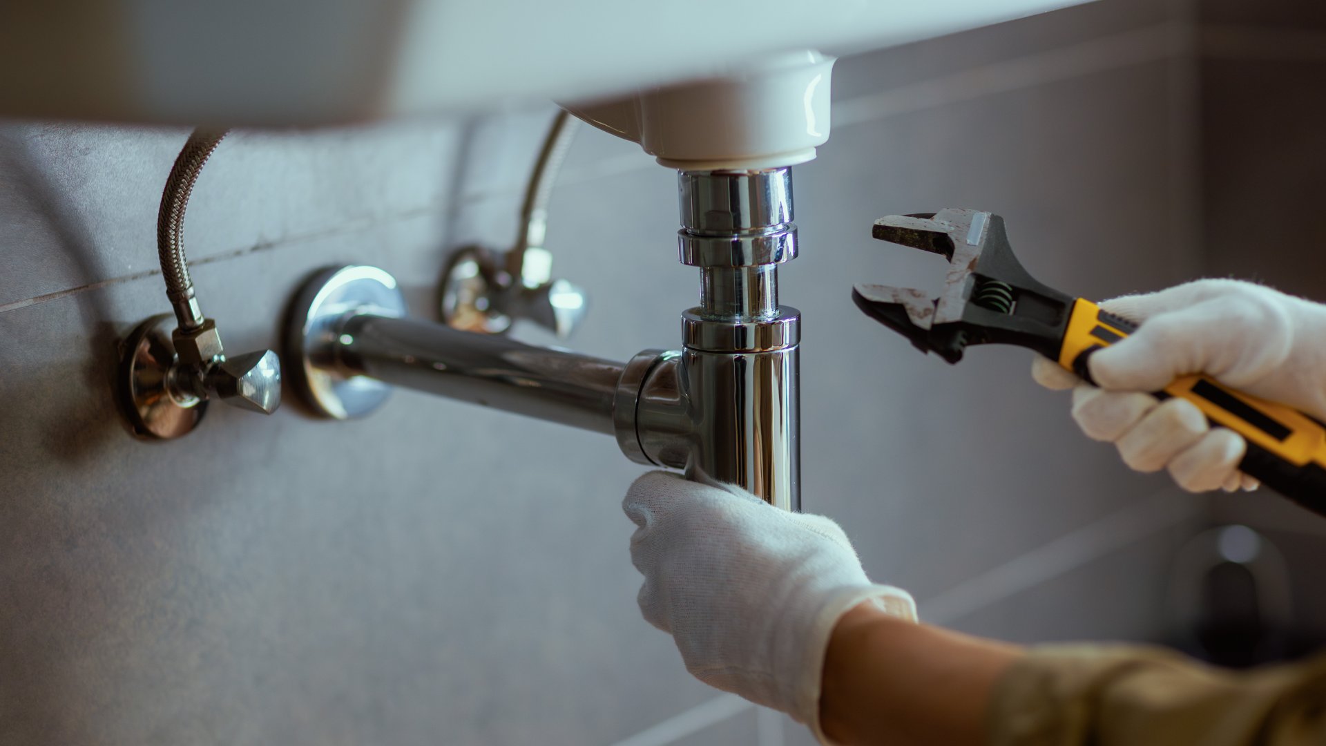 Plumber fixing pipework in a Manchester home