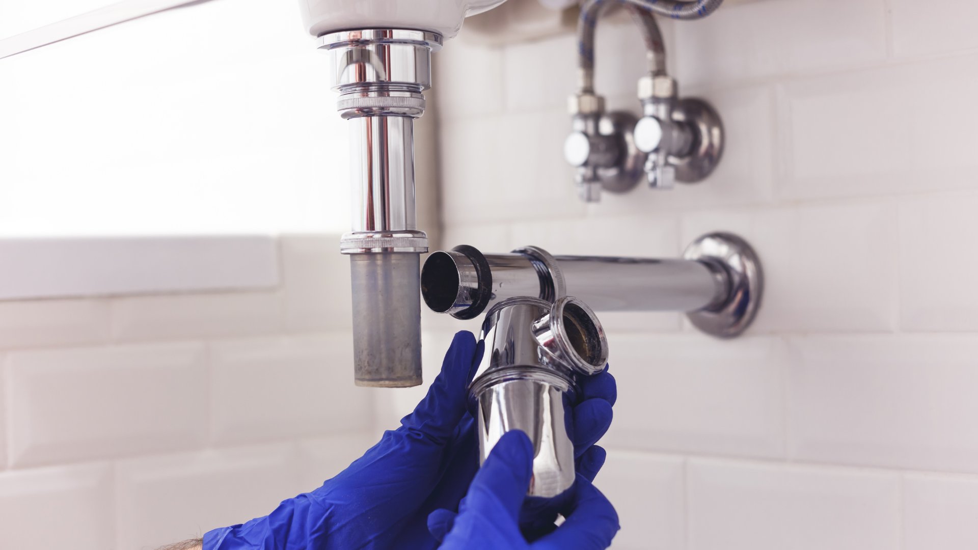 Plumber working on a ubend pipe repair
